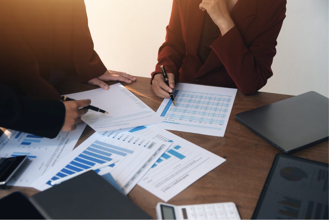 Colleagues reviewing charts and reports at a desk