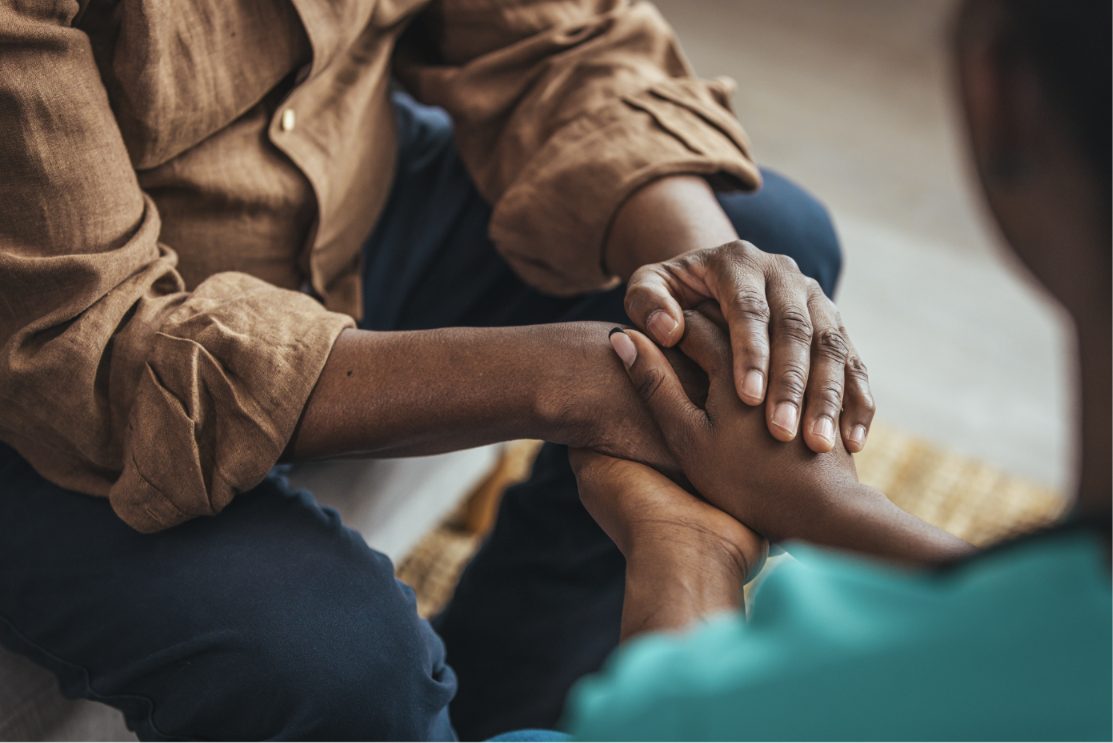 A community worker holding the hands of a person she is supporting